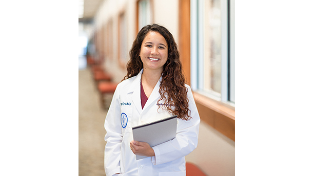 student in lab coat with a notepad